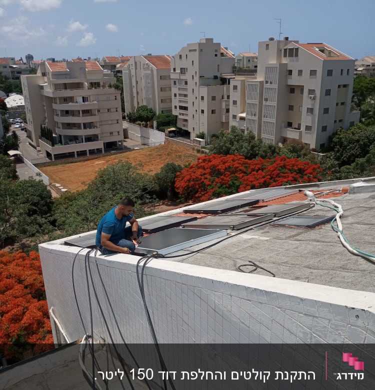 אדם מתקין דוד שמש על גג בניין